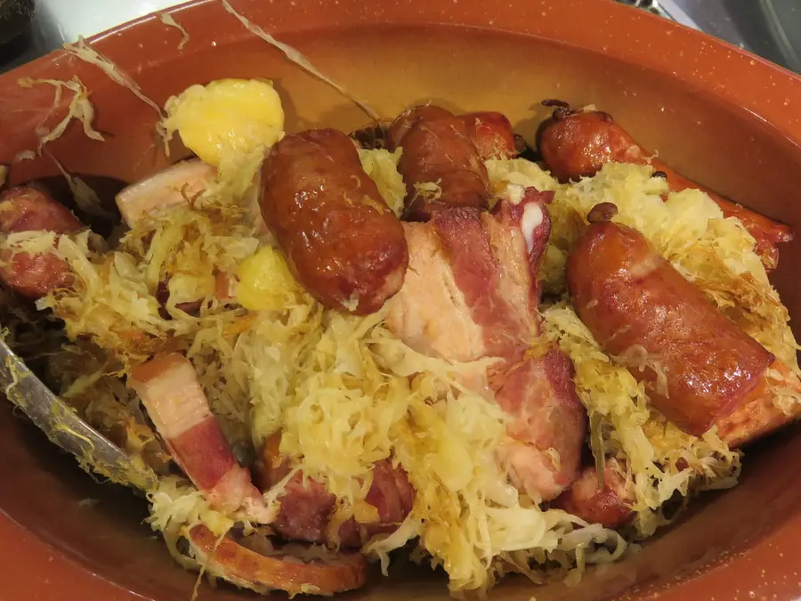 Choucroute garnie servie en cocotte de terre avec ses viandes
