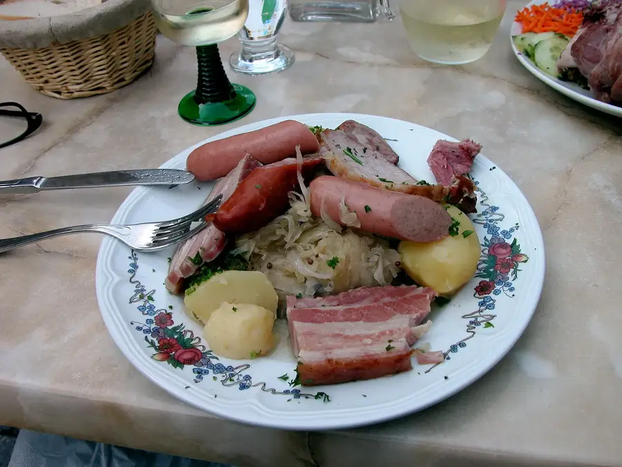 Assiette de choucroute garnie avec verres de vin blanc d'Alsace sur une table de brasserie