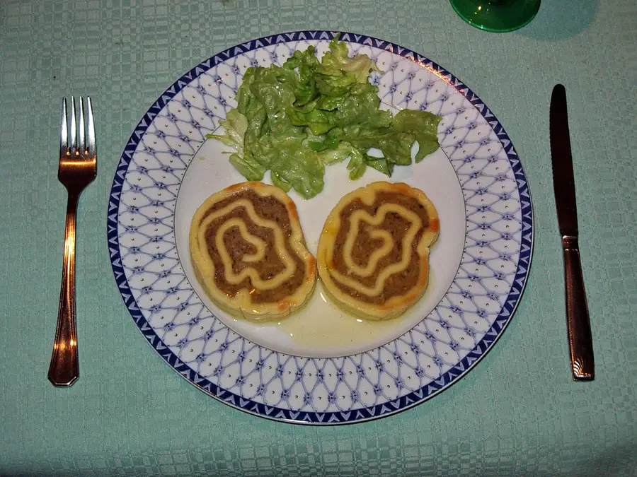 Deux fleischschnacka dans l'assiette, spirale de pate et farce visibles