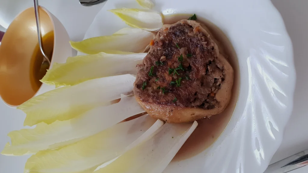Fleischschnacka doree servie avec sa sauce et des endives