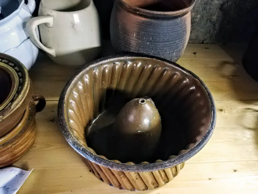 Moule à kougelhopf en terre vernissée d'Alsace posé sur une table
