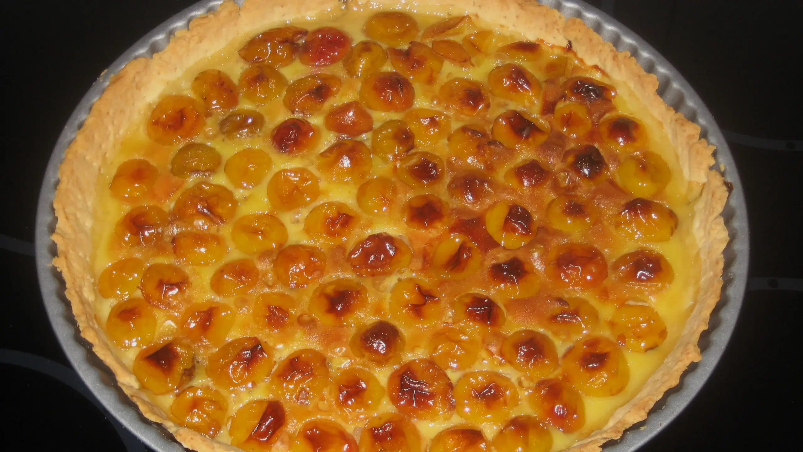 Tarte aux mirabelles entière dans son moule, fruits dorés