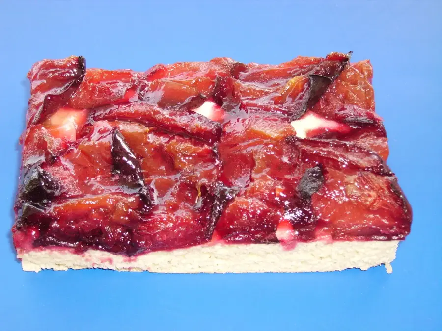 Part de tarte aux quetsches aux fruits serrés et caramélisés sur une pâte épaisse