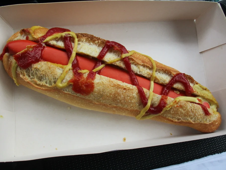 Saucisse de type knack dans un petit pain avec moutarde et ketchup, façon hot-dog